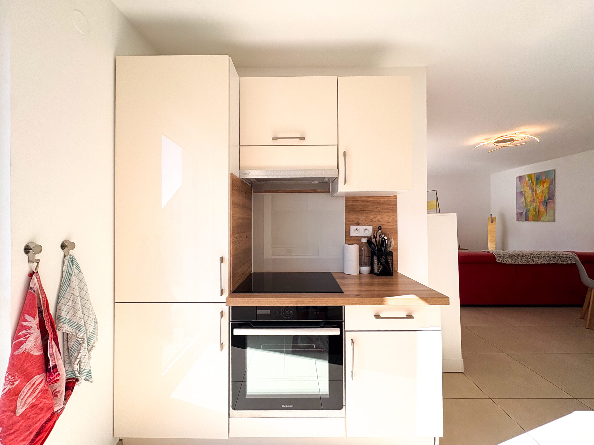 Cuisine — plaque induction et four, ouverture sur le salon